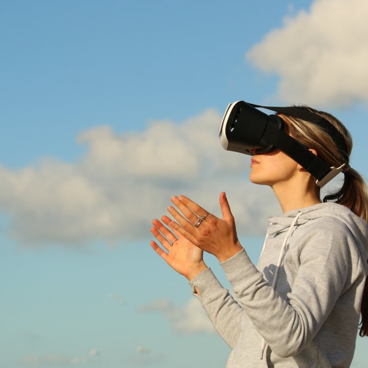 woman staring into sky with vr goggles